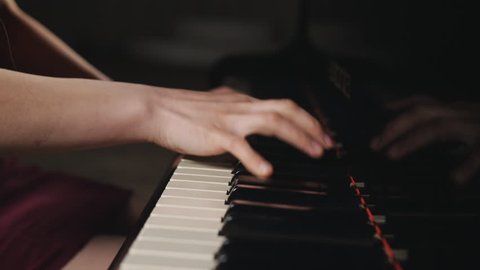 Close-up of woman's hands playing the piano. Musical instrument grand piano details.