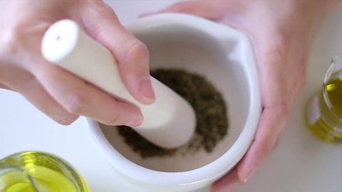 the scientist  doctor is making natural  herb medicine or cosmetic in the laboratory. grind herbal  in the mortar . on table with  organic essential oil . skincare health product .closeup slow motion