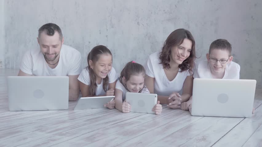 Parents and children play gadgets and laugh