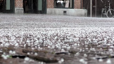 Hail turns the streets of the city white.