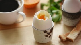 Eating soft boiled egg with toasted bread. Someone dipping bread into egg yolk. Breakfast time - Powered by Shutterstock - Get 15% off with code: PIKWIZARD15