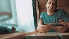 man playing an online game on a smartphone, strong emotions, anger man sitting in a train by the window. slow lifestyle motion video. train emotions joy surprise journey concept