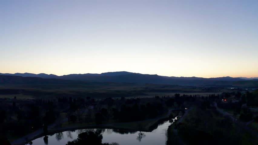 Aerial Backward Fly Over of twilight Hart Park Lake in Bakersfield, California