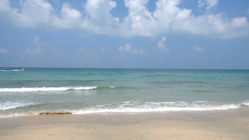 Alluring view of sea view with dense white fluffy clouds on the sky.
Small jet boat entering the ocean., Waves hitting the shore.
