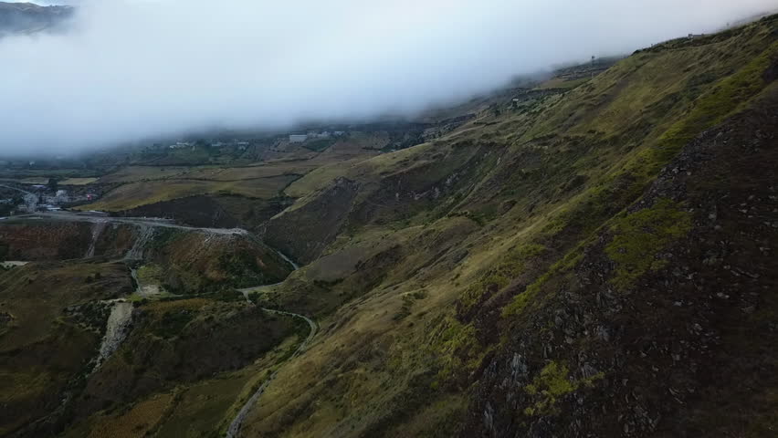 Aerial turn revealing roads through the Andes on a cloudy day