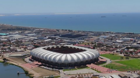 Port Elizabeth, South Africa - circa 2010s: Aerial orbit around Nelson Mandela Bay Stadium. Wide view of stadium in context of industrial area, situated next to North End Lake