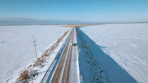 AERIAL: 4K drone aerial of frozen Lake Winnipeg in Manitoba, Canada and Grassy Narrows Marsh near Hecla, Gull Harbour, and Riverton. Onlooking the reed-filled marsh is the snowy, icy, cold lake.