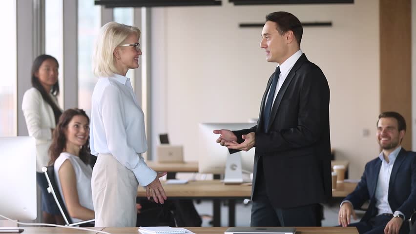 Middle aged male executive manager promote congratulate with career growth handshake proud female employee reward praise motivate appreciate for good work result, respect feedback recognition concept Royalty-Free Stock Footage #1028099051