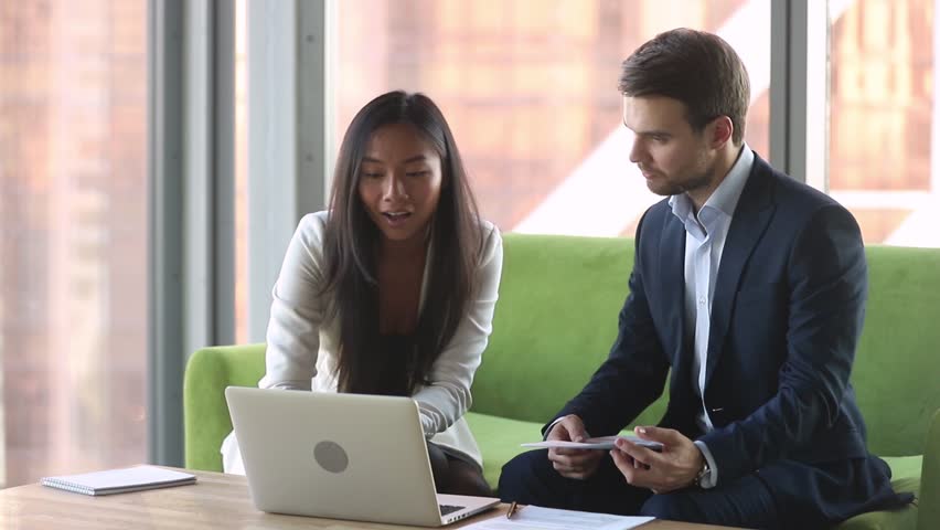 Female asian manager broker advisor consulting caucasian male client with laptop showing online presentation of contract benefits talking to customer explaining deal details convincing buy services | Shutterstock HD Video #1028099144
