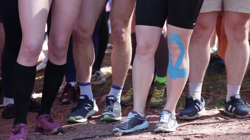 KRYVYI RIH, UKRAINE - APRIL, 2019: Crowd of amateur athletes standing on a start of marathon, many legs close-up People for a healthy lifestyle.