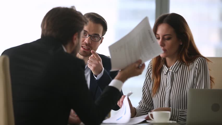 Dissatisfied workers disputing with colleague over contract terms, business partners arguing about financial report mistakes, disputing agreement details with lawyer sitting at modern desk in office Royalty-Free Stock Footage #1028104289