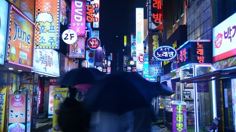 SEOUL, SOUTH KOREA - APRIL 16, 2012 Time Lapse of Seoul City Crowd of People Visit Busy Shopping Street Rainy Night