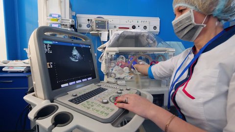 Female doctor is making an ultrasound to a little baby