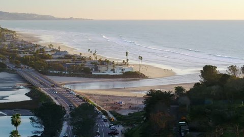 Aerial video of Del Mar coastline, overlooking dog beach with trees in the foreground.