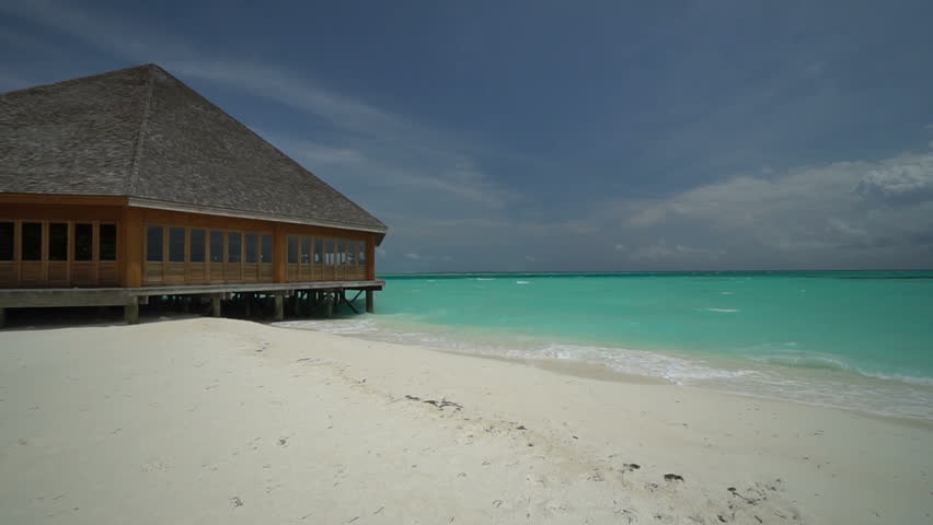 Living by a beachside house on a sandy dream destination, on a dull azure day in Maldives