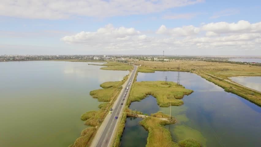 Two Way Road Between Lakes With Moving Cars 