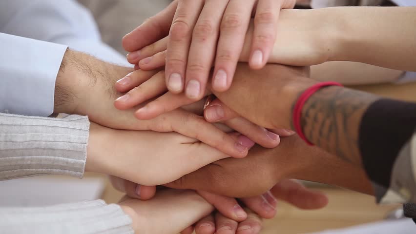 Close up multinational group of people stack hands put palms together, united different ethnicity employees makes common business, students good warm relations, support, trust and teambuilding concept