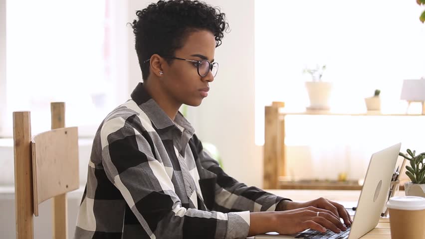 Side view disgruntled african ethnicity student girl study, typing looks at laptop screen feels dissatisfied received unpleasant e-mail message, employee made mistake in report, slow internet concept | Shutterstock HD Video #1028137055