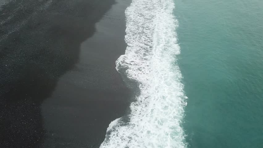 Aerial view wave hit the black sand seaside in the misty morning at Kaikoura, South Island, New Zealand.