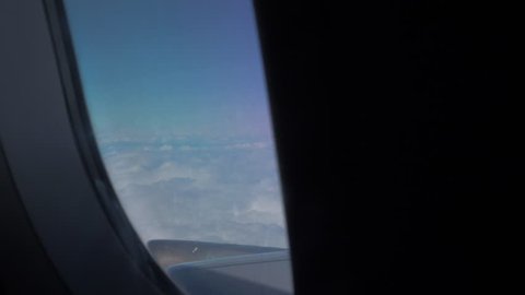 Airoplane Window reveal of blue sky and clouds