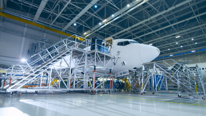 Aircraft Maintenance Mechanic and Chief Engineer Have Discussion, Consult Blueprints While Standing in a Big Airplane Development Facility. They Analyze, Inspect, Develop and Design Airplanes Royalty-Free Stock Footage #1028143247