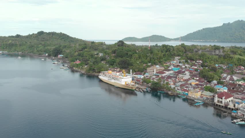 Aerial: flying over Bandaneira village passenger ship Pelni in harbor Indonesia Banda Islands Maluku old dutch colony for nutmeg. Native cinelike D-log color profile