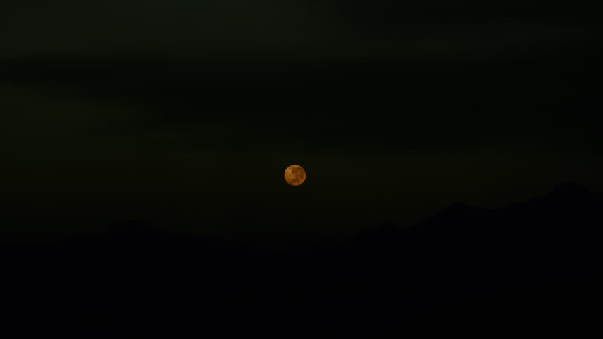 Footage of Super moon setting over the hills during early morning
