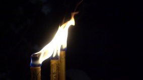 Closeup of yellow candle burn against darkness on black night in the wind as light for life. Dying out the flame. Candle light for spirituality ceremony or worship. 4K video slow motion fps smooth.