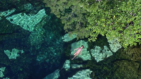Puerto Morelos, Q.R. / Mexico - January 6, 2016: Overhead Shot, Girl Swimming in a Cenotes Natural Pool in Tulum, Aerial Drone
