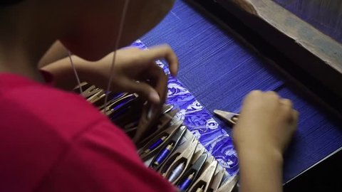 Mandalay, Myanmar - June 27, 2018: Traditional Burmese silk weaving in small factory of Mandalay
