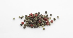 Mix of multicolored pepper rotation footage video. Peas with spices. Herbal spice, aromatic seasoning for food preparation and cooking, macro shot against a white background