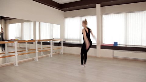 A girl in a sports shirt and leggings dancing in a modern style. Energetic in dance. Hard work