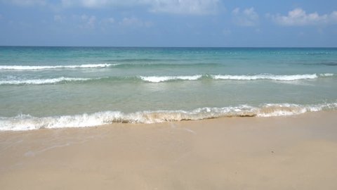 Tropical ocean waves wash ashore a beach,ing towards the camera.