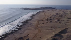 Las Tortolas beach aerial footage at Atacama Desert the sunset ray lights illuminate this amazing and idyllic beach in the middle of the desert, an arid awe landscape crashed by Pacific Ocean waters