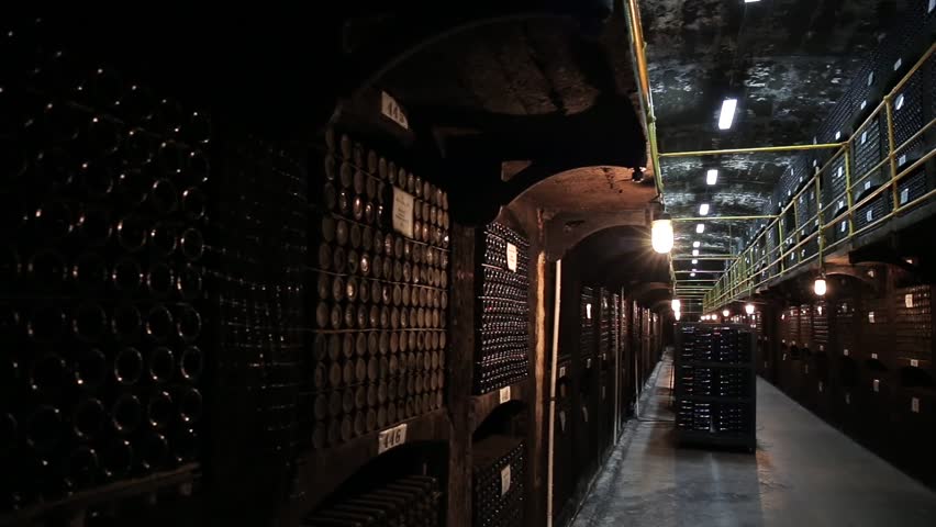Wine cellar with many dusty bottles of alcohol, fermentation of old wine.