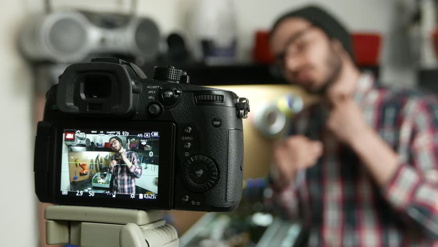 Millennial hipster vlogger prepares to film a video of himself to post on social media.