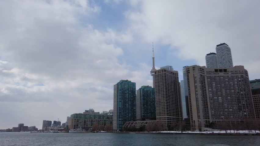 Toronto city skyline seen from a boat as it crosses frozen lake Ontario on a cold winter day
