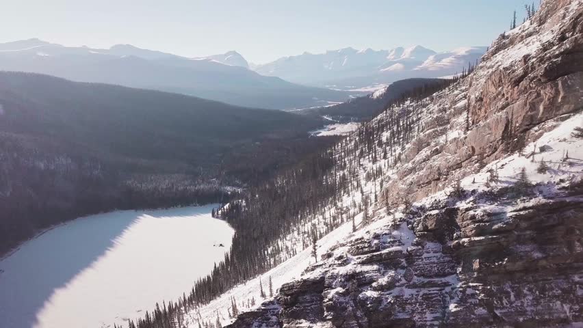 ARIEAL: 4K Drone shot of Lake and Canadian Rocky Mountains. Mountain Drone Ariel footage near Banff, Canmore, Jasper, Lake Louise, Canadian Rocky Mountains. Royalty-Free Stock Footage #1028204900