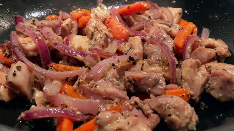 Juicy chopped chicken is fried in a pan with vegetables and spices. A typical meal for a low-carb diet
