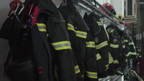Firefighter uniforms and equipment hanging in row in fire station