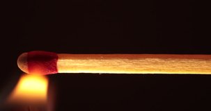 Macro clip of a match igniting and charring as the flame moves along the stick.