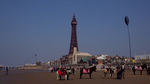 Blackpool, Lancashire / England - April 18 2019: Blackpool is famous for its tower which is a similar in design to the Eiffel tower in Paris. It is a holiday seaside resort in the UK time lapse 4K 