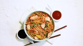Chicken Hakka/Schezwan noodles footage / video, served in a bowl with chopsticks. selective focus