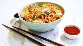 Chicken Hakka/Schezwan noodles footage / video, served in a bowl with chopsticks. selective focus