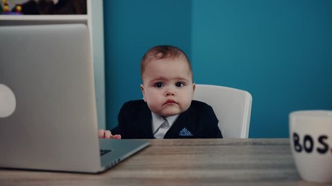 Little child businessman boss in office use laptop look at camera sitting play creative boy happy job kid work child computer education young suit cute career confident slow motion