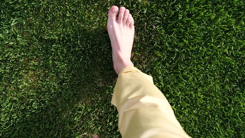 Woman Feet Walking On Grass In The Morning. Health And Relaxation Concepts.