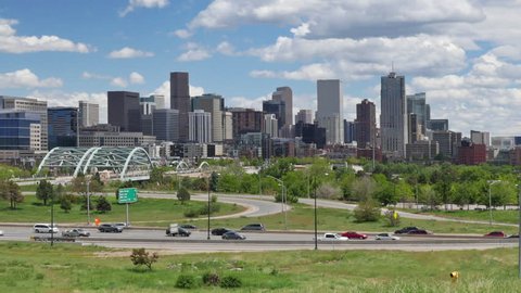 Time lapse pan of Denver skyline with Interstate traffic in the foreground and active clouds above. HD 1080p.