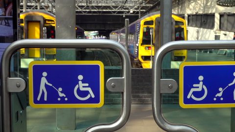 EDINBURGH, SCOTLAND, APRIL 20TH 2019: Slow motion shot of barriers to platforms with sign restricting entry to disabled people and those with children in buggies / strollers at train station.