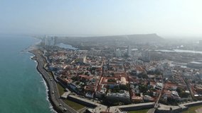 Aerial shot historic center of Cartagena Colombia, flying over colonial buildings background sea
