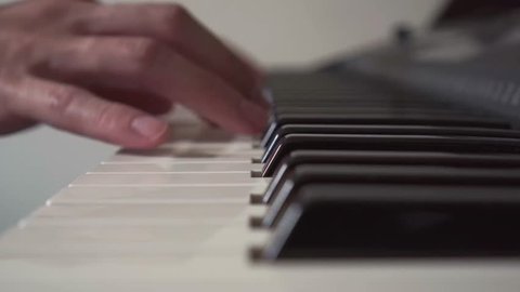 Side View Of A Pianist Hand Playing Notes On Keyboard
